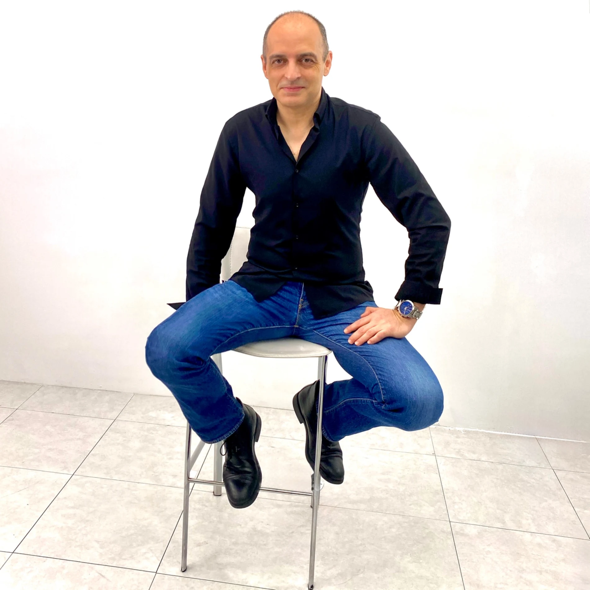 A relaxed portrait of Ivan Yanakov in a dark shirt and blue jeans
